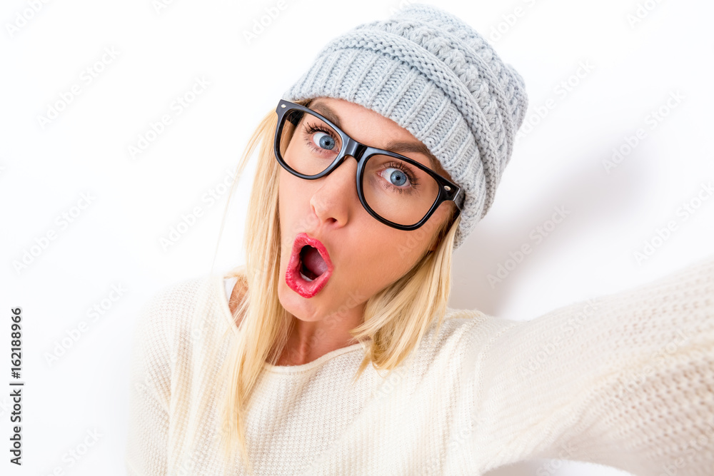 Young woman taking a selfie on a white background