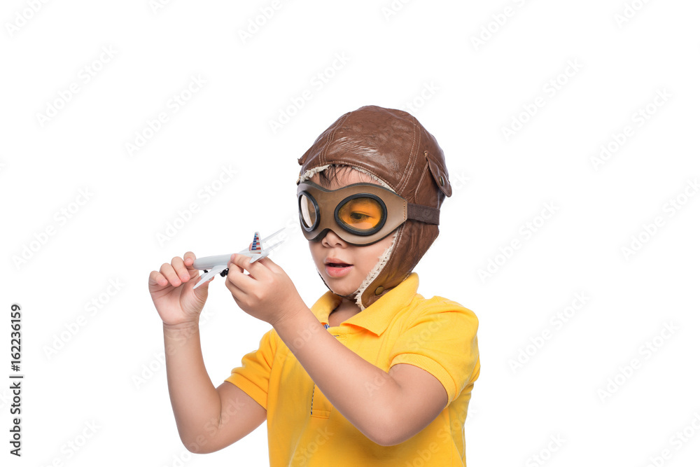 Beautiful smiling child boy in helmet on a white background playing with a plane.