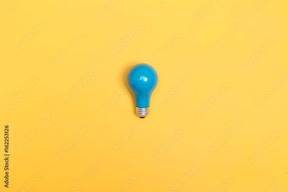 Blue painted light bulb on a vibrant background