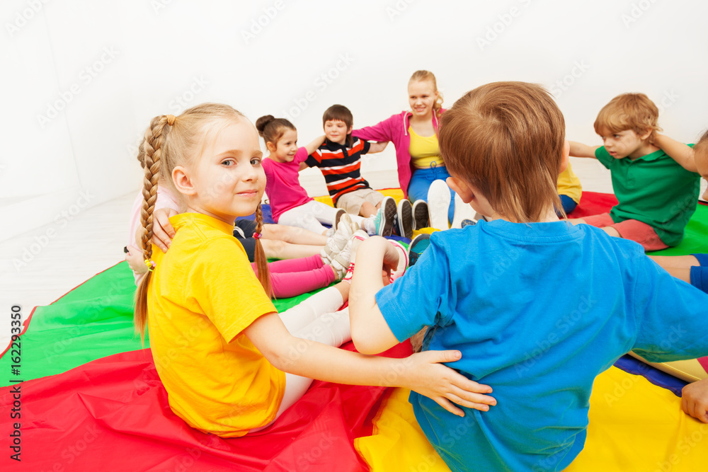 Cute girl playing circle games with friends in gym