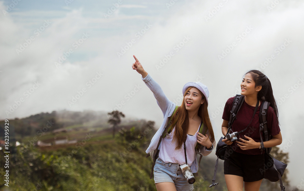 亚洲女游客看到山上的薄雾很兴奋，她指着