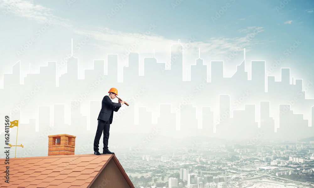 Engineer man standing on roof and looking in spyglass. Mixed med