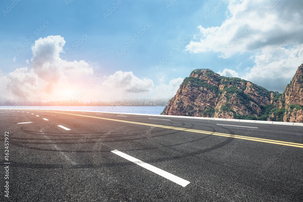 asphalt road and mountain under the blue sky