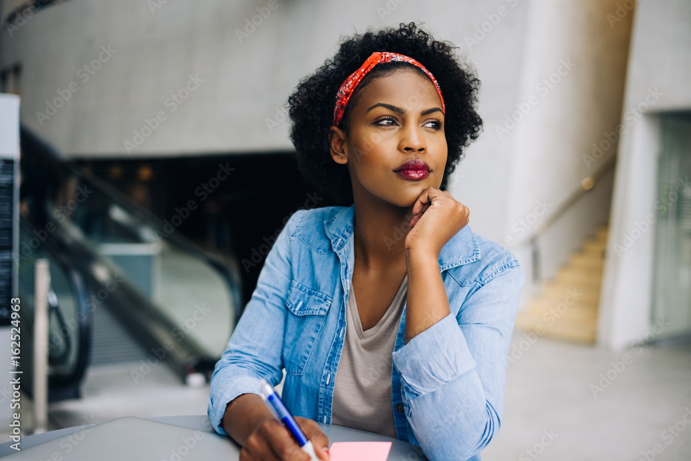 Focused young African female entrepreneur thinking up new busine