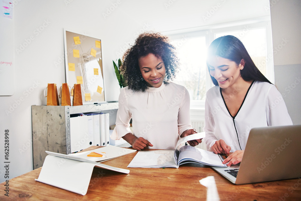 Two happy young women in business together