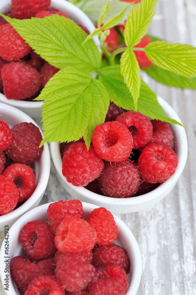 framboises dans petits bols avec feuillage