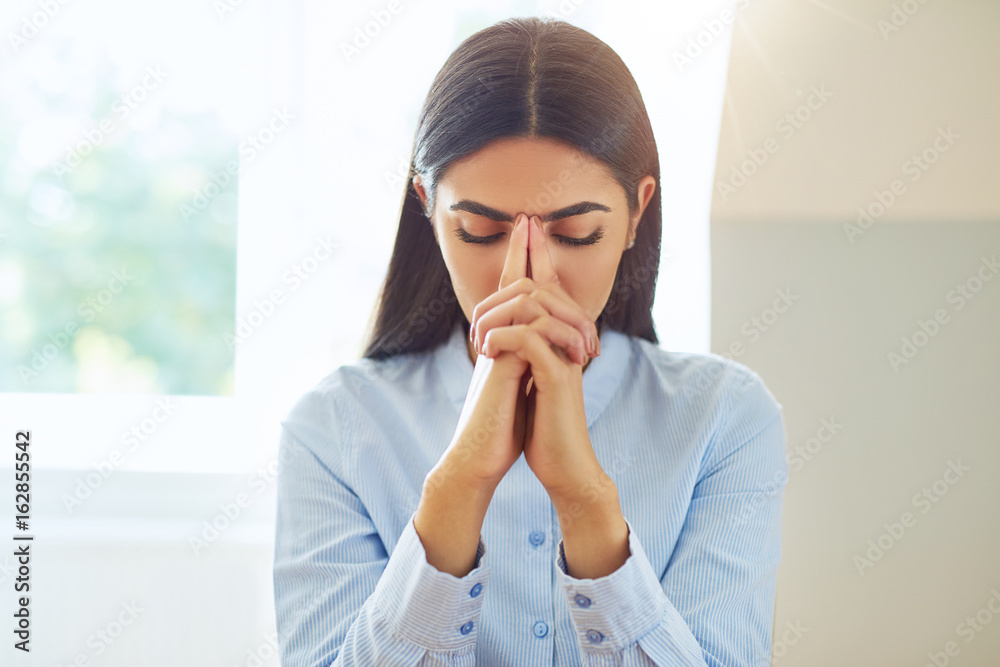 Single woman praying or in deep thought