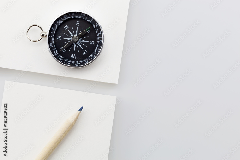 Business direction concept ,business white paper with compass and pencil on white background.