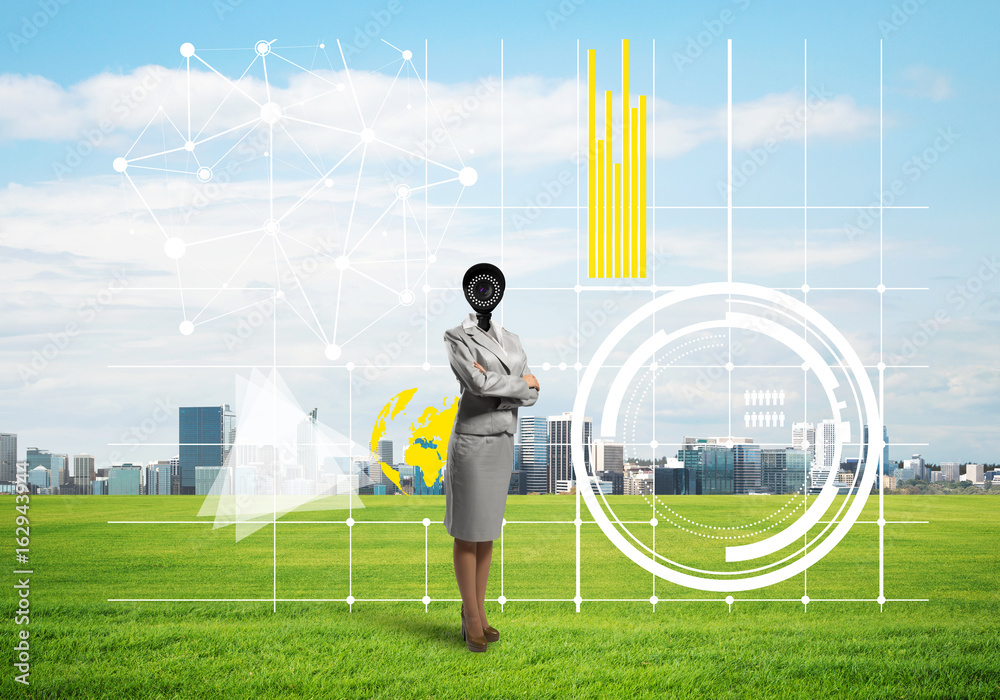 Camera headed woman standing on green grass against modern cityscape