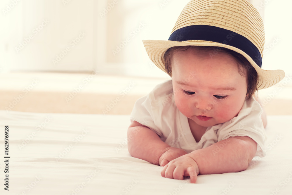 Happy baby boy with a straw hat