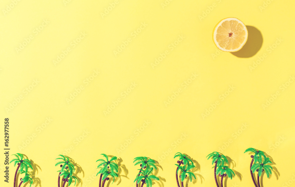 Palm trees and lemon sun flat lay on yellow background