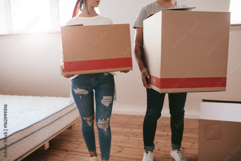 Couple with big cardboard boxes moving to new place