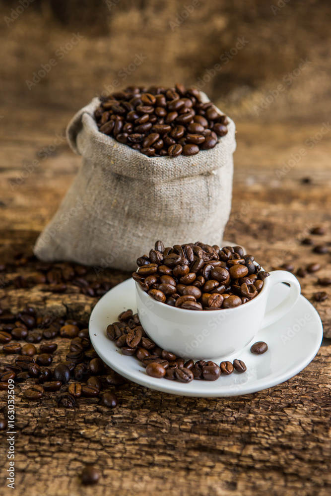 Coffee cup with coffee bag on wooden table. Coffee cup and coffee beans on a wooden table and sack b