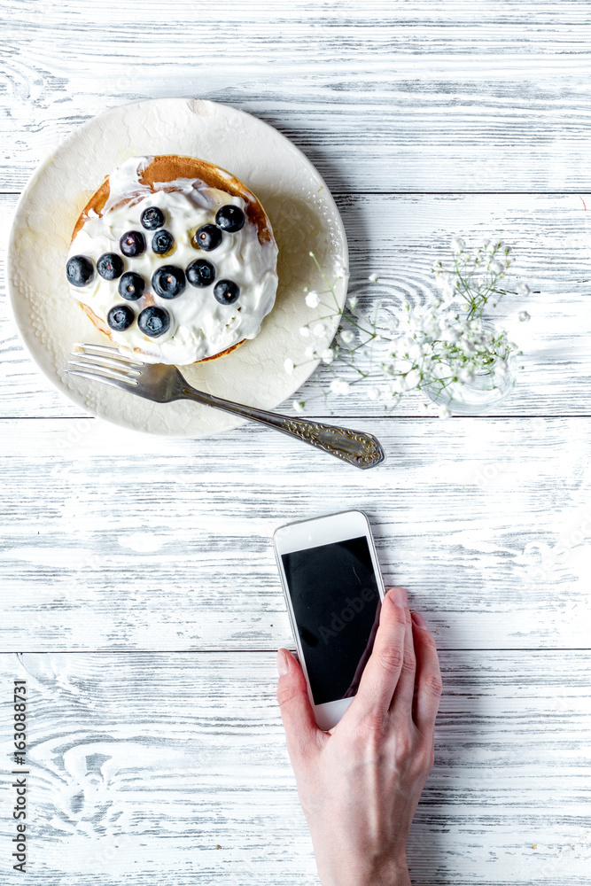 Breakfast concept with flowers on wooden background top view