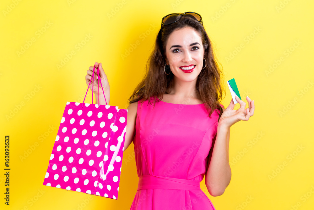 Young woman holding a credit card and a shopping bag