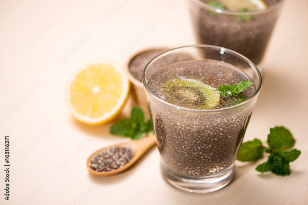 Selective focus of chia seeds drink with water in transparent glass with lemon balm.