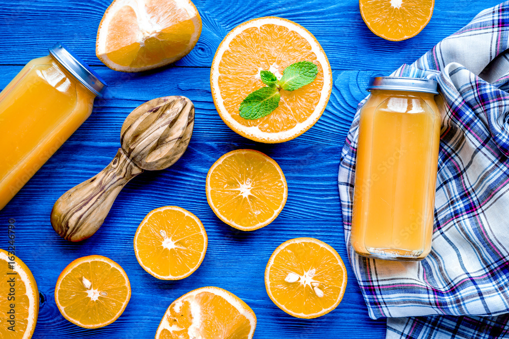 Homemade juice bottles with orange and mint on table top view