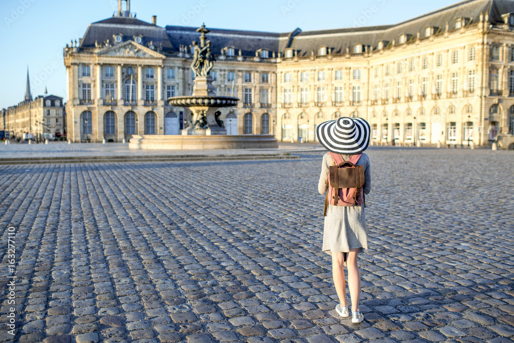 Young woman tourist standing back enjoying view on the famous Bourse square with beautiful buildings