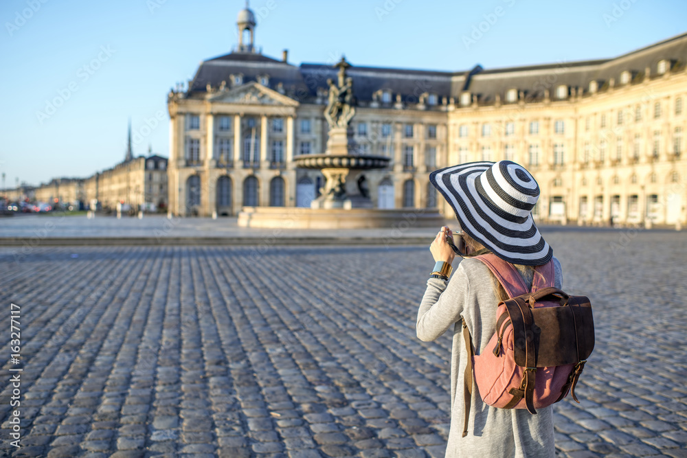 Young woman tourist standing back enjoying view on the famous Bourse square with beautiful buildings