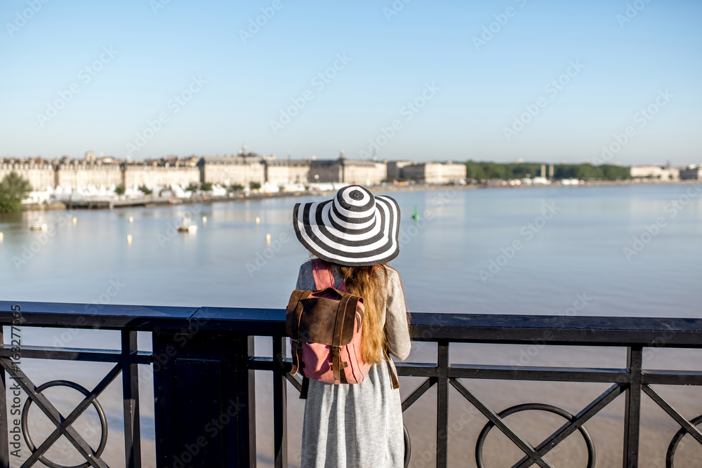 Young woman tourist enjoying great view on the city standing on the famous Pierre bridge in Boredaux