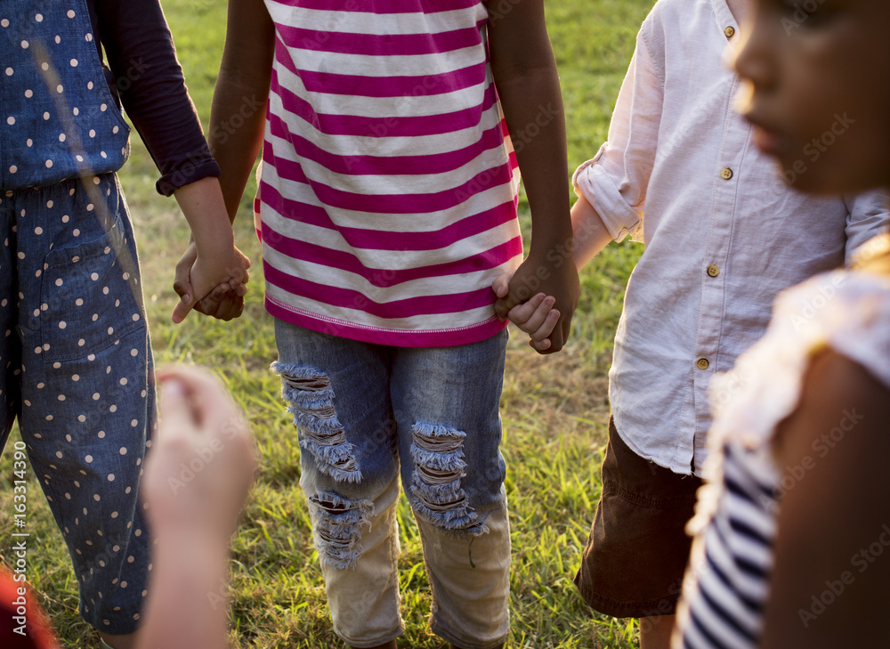 Group of kindergarten kids friends holding hands playing at park