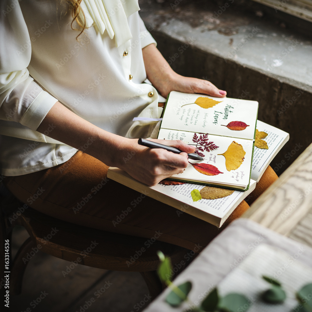 Hands Writing Detail of Dried Flowers Collection in Notebook Handmade Work Hobby