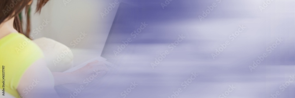 Back of woman typing on laptop with blurry purple transition