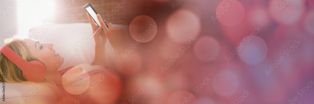 Woman with headphones texting on couch with red bokeh transition