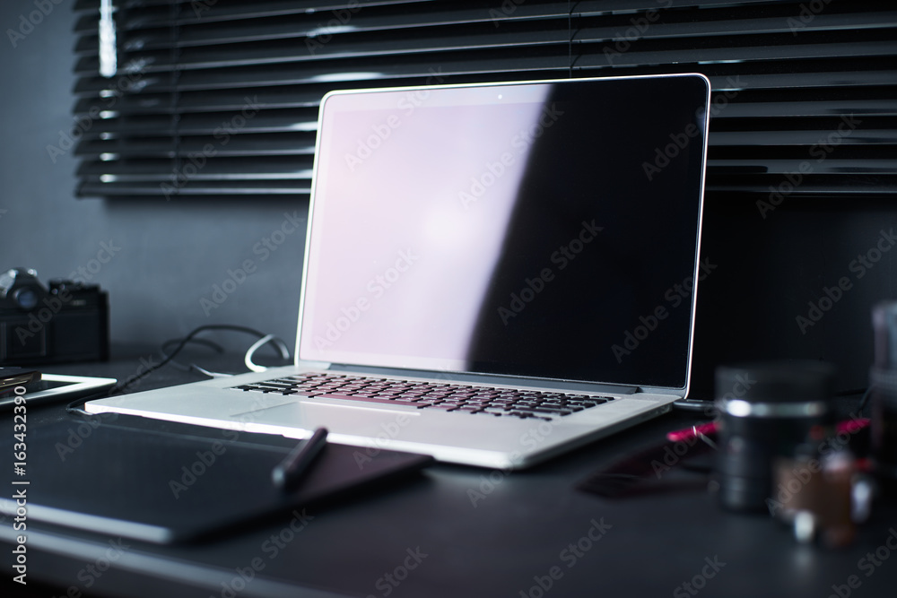 Work space on black table of a photographer or designer with laptop , retro camera , Stylish home st