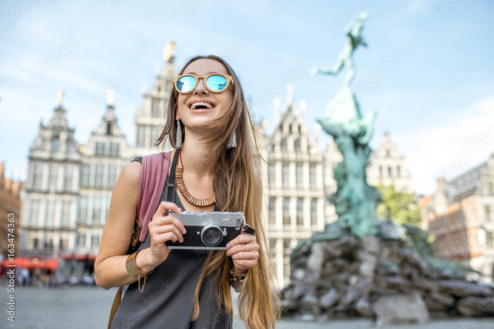 Portrait of a young woman tourist with photo camera on the Great Market square in Antwerpen city in 