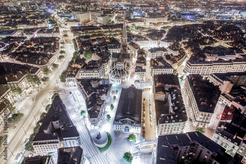 Aerial cityscape view with illuminated streets and buildings in Nantes city during the night in Fran