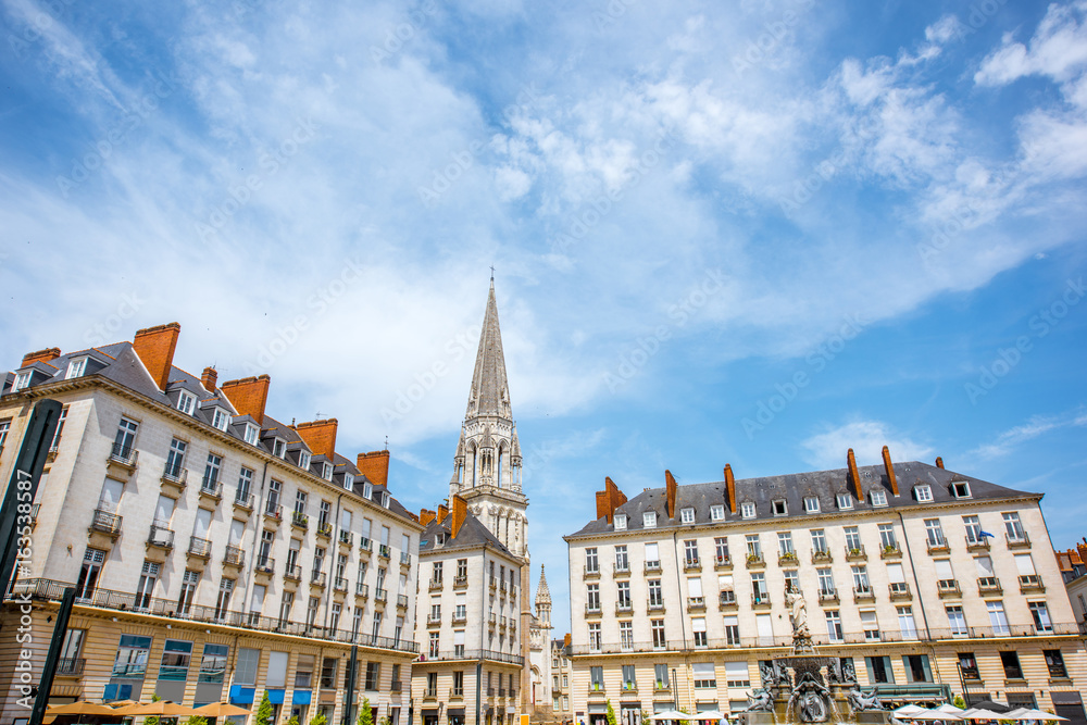 View on the Royal square with fountain and church tower in Nantes city in France