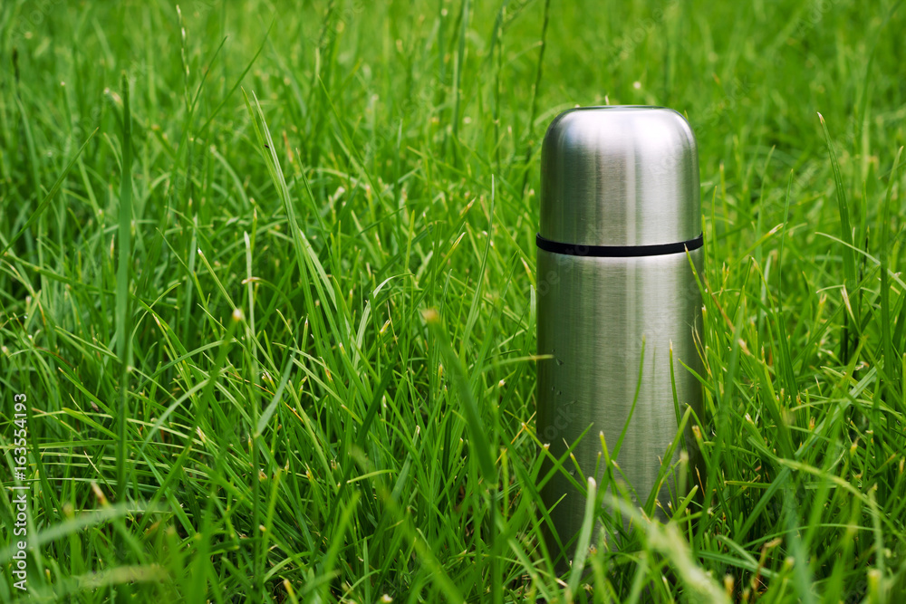 Vacuum metallic flask in the grass