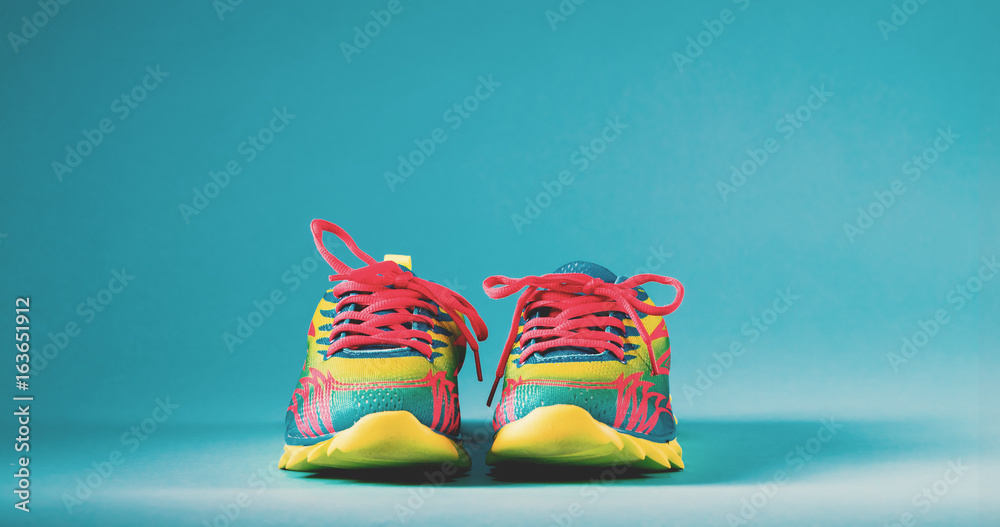 Pair of colorful running sneakers on a blue background