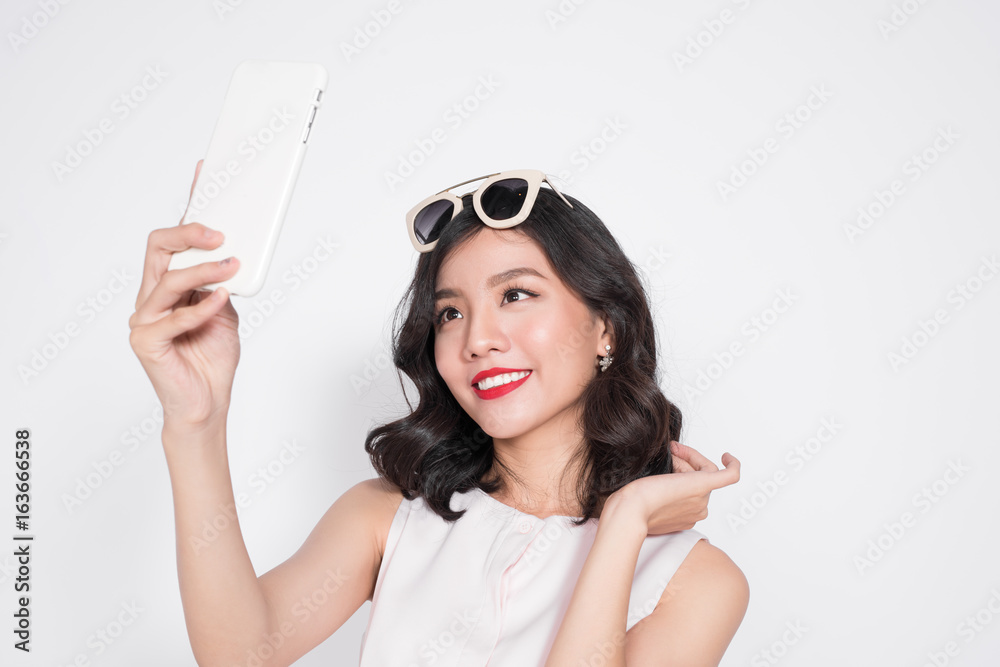 Portrait of beautiful asian fashionable girl taking selfie