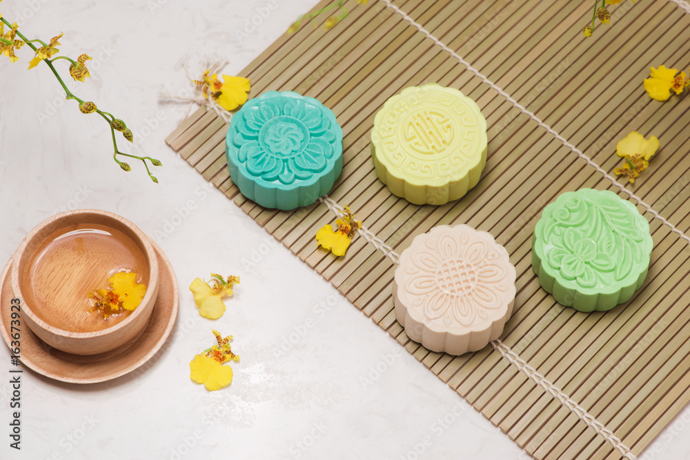 Sweet color of snow skin mooncake. Traditional mid autumn festival foods with tea on table setting.