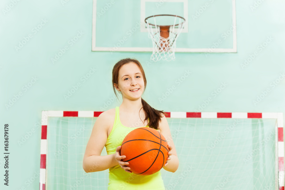 Pretty teen girl with ball during basketball game