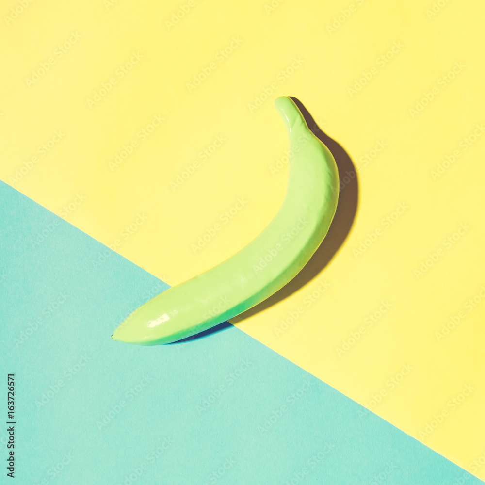 Painted banana on a vibrant split tone background