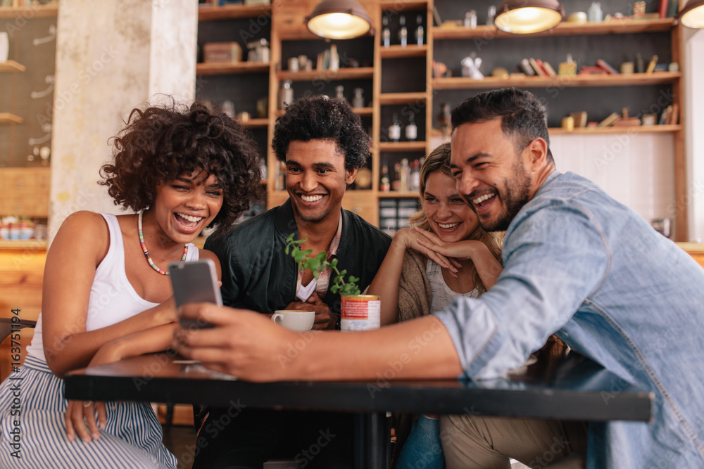 Group of friends meeting at cafe using cell phone