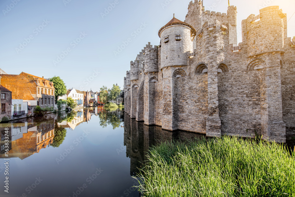 Riverside view with beautiful old buildings and castle walls during the morning light in Gent city, 