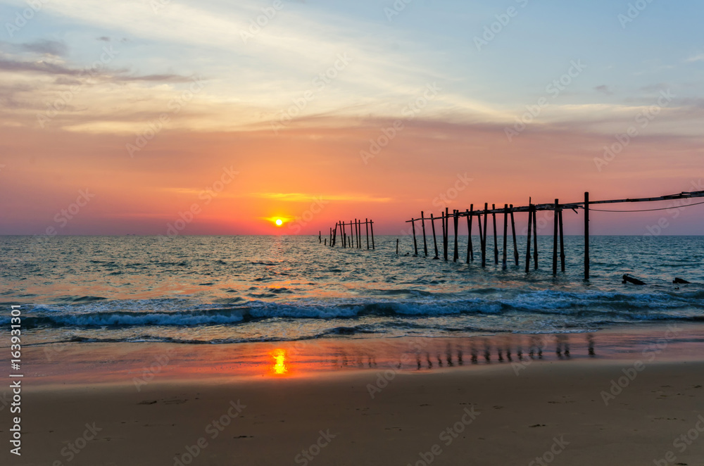 Evening light during sunset on the sea with an old wooden bridge.