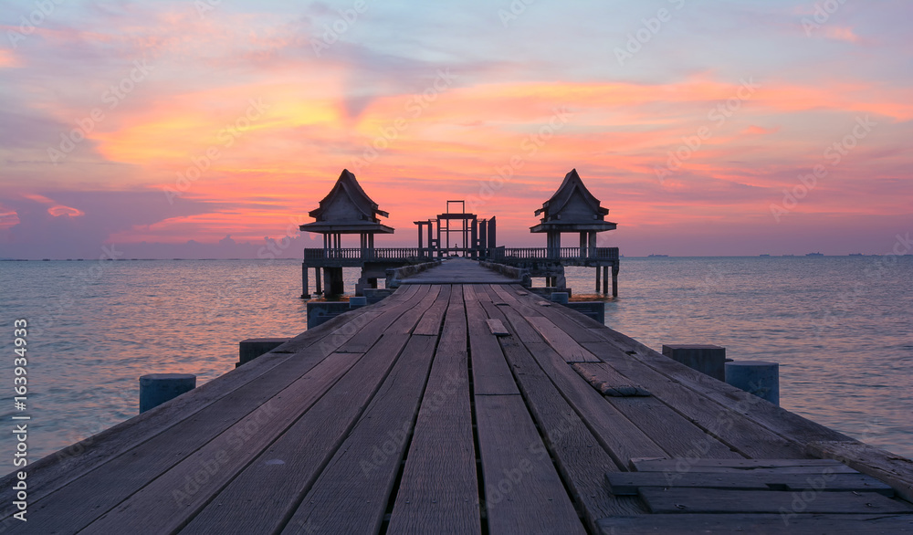 The sun reflected off the wooden bridge that stretches into the sea.In Chonburi Thailand.