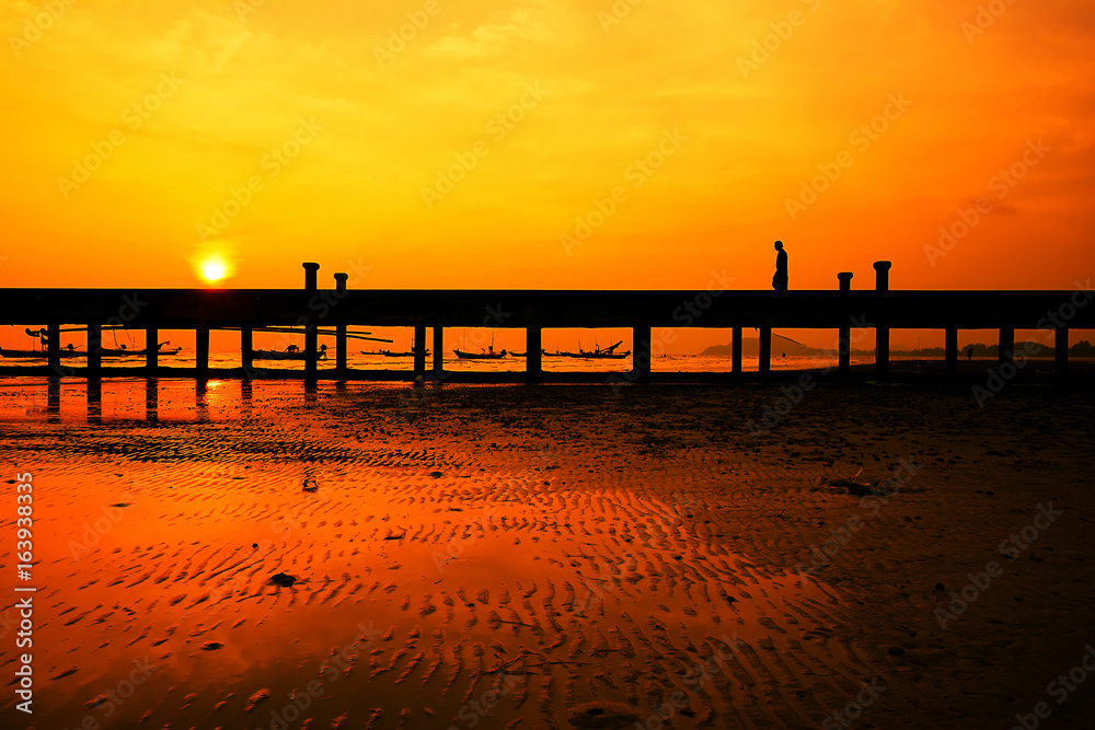 The evening will have people waiting to watch the sunset on the bridge at sea.