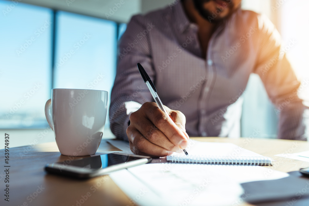 Businessman making notes at his desk.