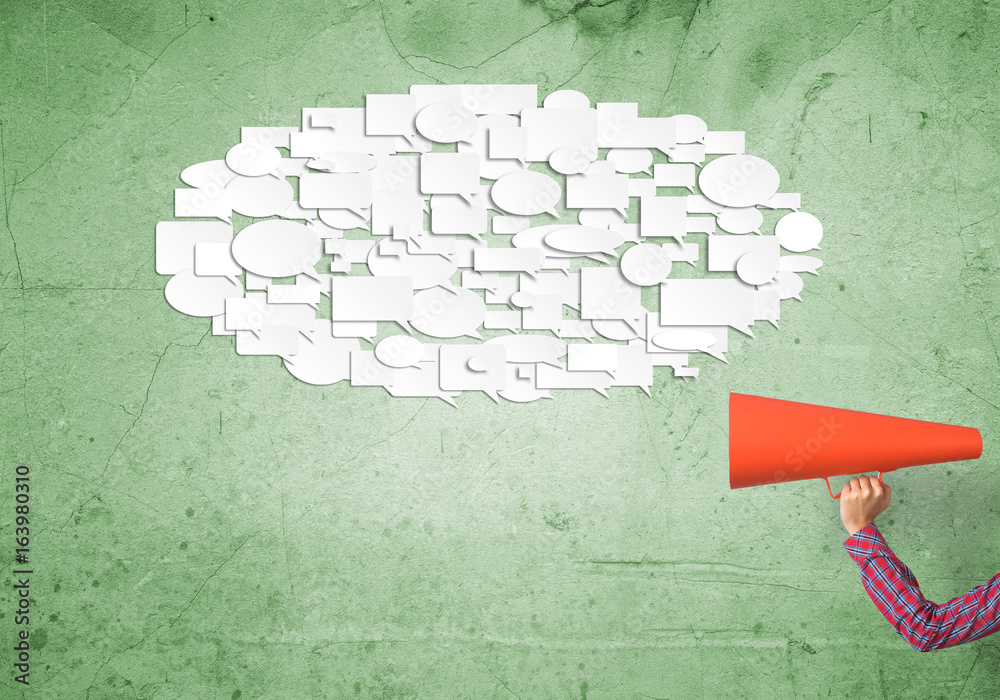 Hand of woman holding red paper trumpet and speech cloud