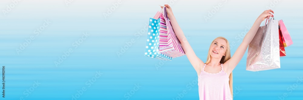 Shopper with bags in air against blurry blue background