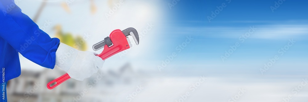 Hand with clamp on building site  with sky transition effect