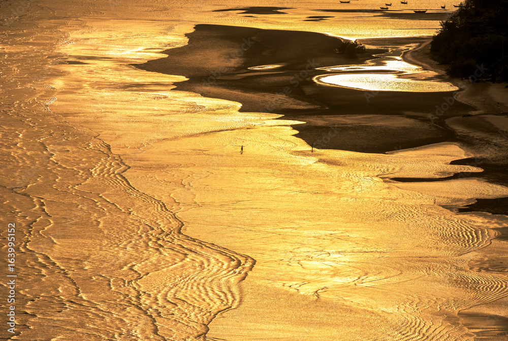 Ocean and golden light on the beach at dusk.