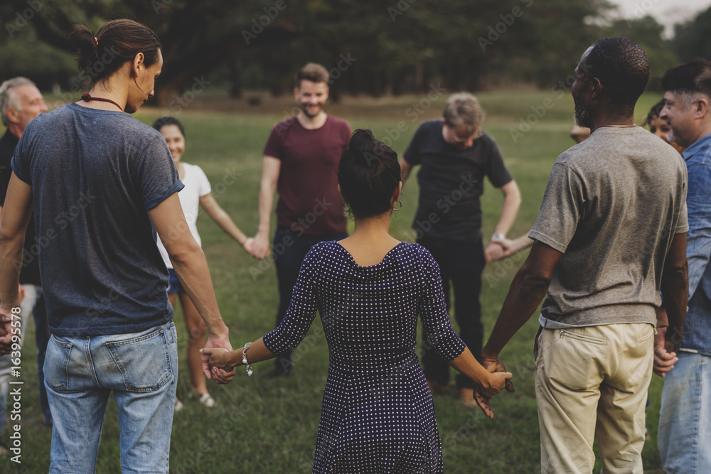 Group of people holding hand together in the park