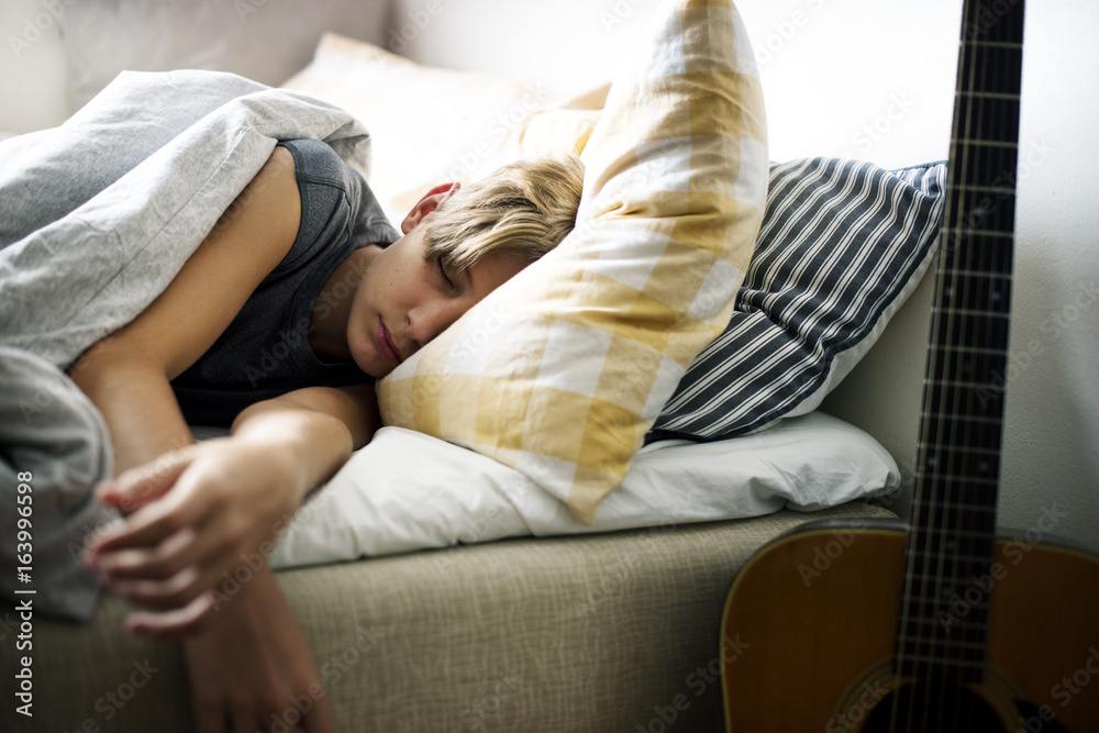 Young caucasian boy sleeping in bed